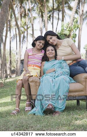 Mature woman sitting with her two daughters in an armchair View Large Photo Image Stock Photo - Mature woman sitting with her two daughters in an armchair. Fotosearch