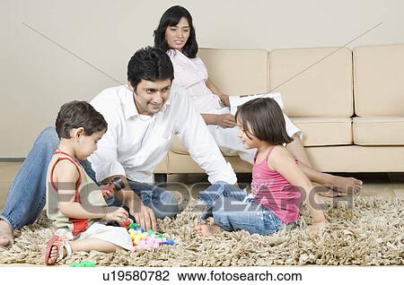 Stock Image - Mid adult man playing with his children. Fotosearch