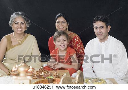 Stock Image - Portrait of a family sitting in deepavali pooja. Fotosearch