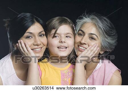 Portrait of a girl touching cheek of her mother and grandmother View Large Photo Image Picture - Portrait of a girl touching cheek of her mother and grandmother. Fotosearch