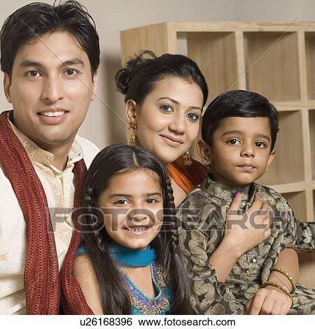 Portrait of a young couple sitting together with their son and daughter View Large Photo Image Stock Photograph - Portrait of a young couple sitting together with their son and daughter. Fotosearch