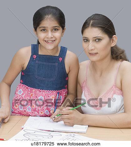 Portrait of a young woman helping her daughter in drawing View Large Photo Image Stock Photography - Portrait of a young woman helping her daughter in drawing. Fotosearch