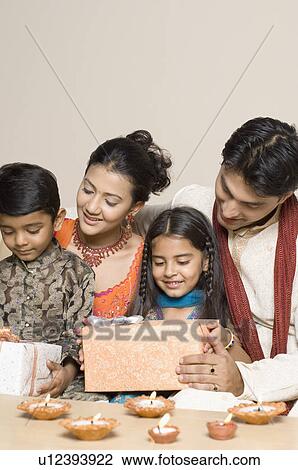 Young couple with their son and daughter holding diwali gifts View Large Photo Image Stock Image - Young couple with their son and daughter holding diwali gifts. Fotosearch