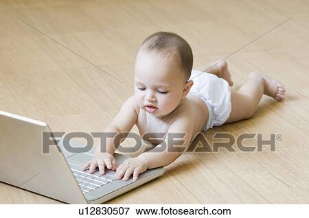 Baby boy playing with a laptop View Large Photo Image Stock Photo - Baby boy playing with a laptop. Fotosearch