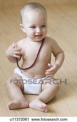 Baby boy sitting on the hardwood floor and wearing a mala View Large Photo Image Stock Image - Baby boy sitting on the hardwood floor and wearing a mala. Fotosearch