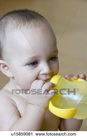 Stock Image - Close-up of a baby boy drinking water from a water bottle. Fotosearch