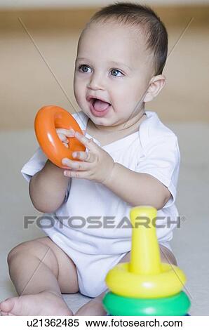 Close-up of a baby boy playing with stacking rings and smiling View Large Photo Image Stock Photography - Close-up of a baby boy playing with stacking rings and smiling. Fotosearch