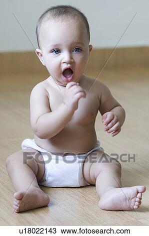 Close-up of a baby boy sitting on the hardwood floor and yawning View Large Photo Image Stock Image - Close-up of a baby boy sitting on the hardwood floor and yawning. Fotosearch