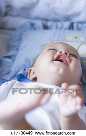 Close-up of a baby lying down and laughing View Large Photo Image Stock Photo - Close-up of a baby lying down and laughing. Fotosearch