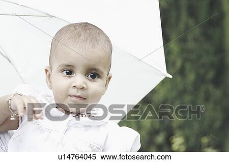 Stock Photography - Close-up of a girl with an umbrella behind her. Fotosearch