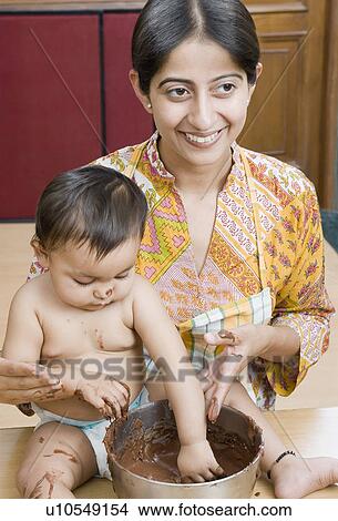 Close-up of a mid adult woman with her daughter eating chocolate sauce View Large Photo Image Picture - Close-up of a mid adult woman with her daughter eating chocolate sauce. Fotosearch