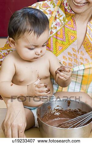Close-up of a mid adult woman with her daughter eating chocolate sauce View Large Photo Image Stock Photo - Close-up of a mid adult woman with her daughter eating chocolate sauce. Fotosearch