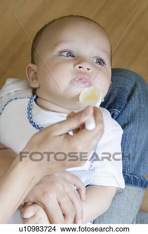 Close-up of a person's hand feeding food to a baby boy View Large Photo Image Picture - Close-up of a person's hand feeding food to a baby boy. Fotosearch