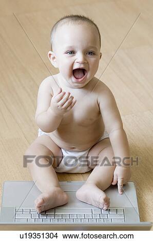 High angle view of a baby boy playing with a laptop and laughing View Large Photo Image Picture - High angle view of a baby boy playing with a laptop and laughing. Fotosearch
