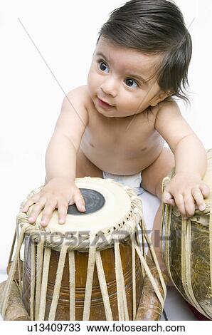 High angle view of a baby boy playing the tabla View Large Photo Image Stock Image - High angle view of a baby boy playing the tabla. Fotosearch