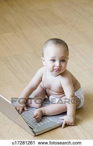 High angle view of a baby boy playing with a laptop View Large Photo Image Stock Image - High angle view of a baby boy playing with a laptop. Fotosearch