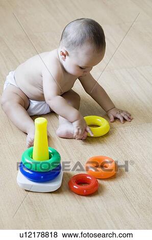 Stock Photo - High angle view of a baby boy playing with stacking rings. Fotosearch