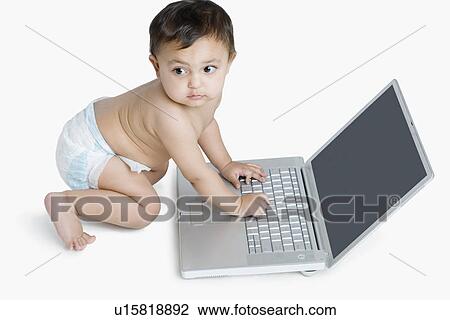 High angle view of a baby girl playing with a laptop View Large Photo Image Stock Image - High angle view of a baby girl playing with a laptop. Fotosearch