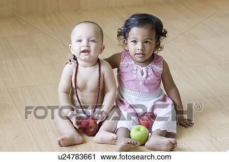 High angle view of a girl sitting with her arm around a baby boy View Large Photo Image Stock Image - High angle view of a girl sitting with her arm around a baby boy. Fotosearch