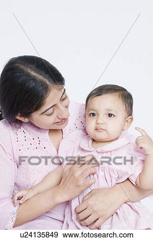 Mid adult woman carrying her daughter View Large Photo Image Stock Photo - Mid adult woman carrying her daughter. Fotosearch