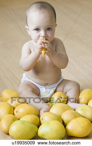 Portrait of a baby boy eating a mango View Large Photo Image Stock Photo - Portrait of a baby boy eating a mango. Fotosearch