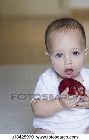 Portrait of a baby boy holding an apple View Large Photo Image Stock Image - Portrait of a baby boy holding an apple. Fotosearch