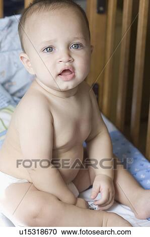 Stock Image - Portrait of a baby boy sitting in a crib. Fotosearch