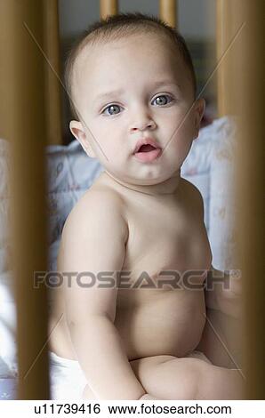 Portrait of a baby boy sitting in a crib View Large Photo Image Stock Photograph - Portrait of a baby boy sitting in a crib. Fotosearch