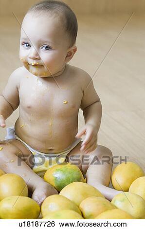 Portrait of a baby boy sitting on the hardwood floor and getting messy with mangoes View Large Photo Image Stock Photograph - Portrait of a baby boy sitting on the hardwood floor and getting messy with mangoes. Fotosearch