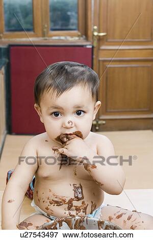 Portrait of a baby girl eating chocolate sauce View Large Photo Image Stock Photo - Portrait of a baby girl eating chocolate sauce. Fotosearch