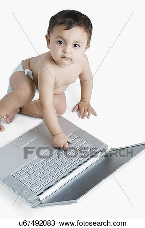 Portrait of a baby girl playing with a laptop View Large Photo Image Stock Image - Portrait of a baby girl playing with a laptop. Fotosearch