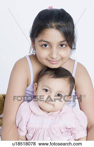 Portrait of a girl sitting with her sister View Large Photo Image Stock Photo - Portrait of a girl sitting with her sister. Fotosearch