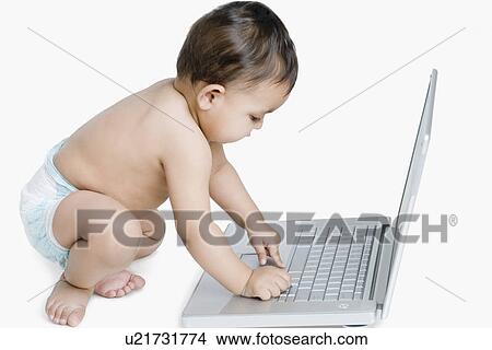 Side profile of a baby girl playing with a laptop View Large Photo Image Picture - Side profile of a baby girl playing with a laptop. Fotosearch