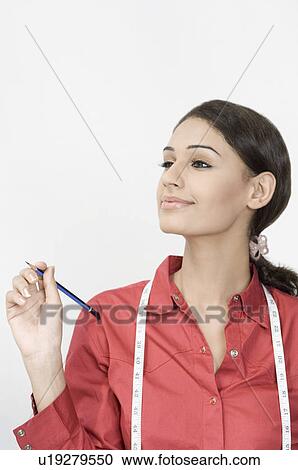 Close-up of a female fashion designer holding a pencil and smiling View Large Photo Image Stock Image - Close-up of a female fashion designer holding a pencil and smiling. Fotosearch