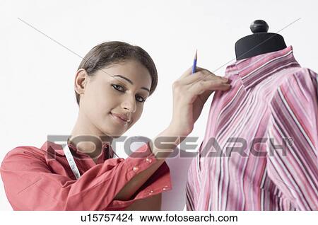 Portrait of a female fashion designer adjusting a shirt on a mannequin View Large Photo Image Picture - Portrait of a female fashion designer adjusting a shirt on a mannequin. Fotosearch