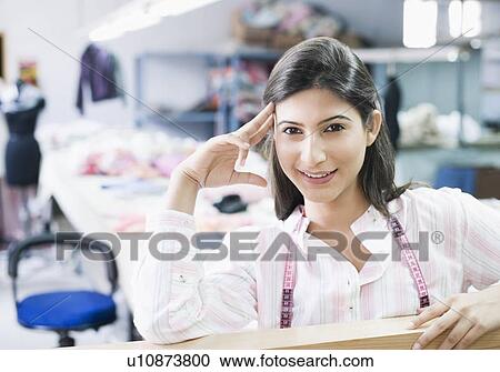 Portrait of a female fashion designer smiling with a tape measure around her neck View Large Photo Image Stock Image - Portrait of a female fashion designer smiling with a tape measure around her neck. Fotosearch