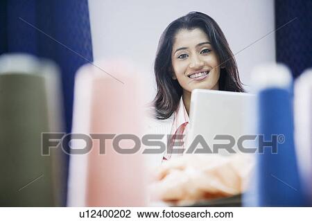 Portrait of a female fashion designer smiling View Large Photo Image Stock Image - Portrait of a female fashion designer smiling. Fotosearch
