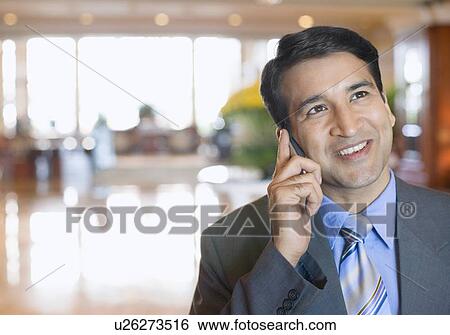 Close-up of a businessman talking on a mobile phone and smiling View Large Photo Image Stock Photograph - Close-up of a businessman talking on a mobile phone and smiling. Fotosearch
