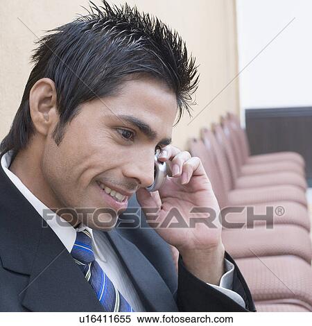 Close-up of a businessman talking on a mobile phone and smiling View Large Photo Image Stock Photography - Close-up of a businessman talking on a mobile phone and smiling. Fotosearch
