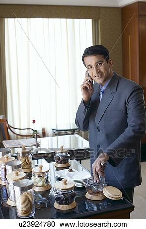 Portrait of a businessman talking on a mobile phone and smiling View Large Photo Image Stock Image - Portrait of a businessman talking on a mobile phone and smiling. Fotosearch