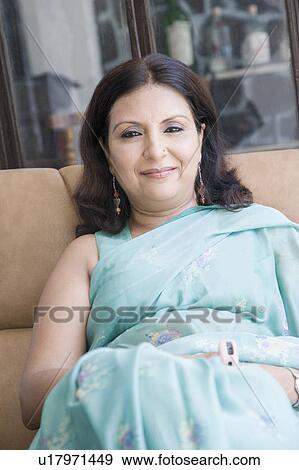 Portrait of a mature woman sitting on a couch View Large Photo Image Stock Photo - Portrait of a mature woman sitting on a couch. Fotosearch