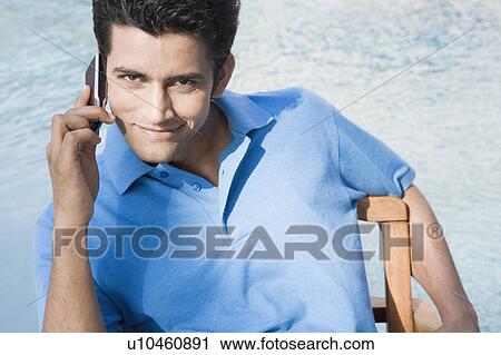 Portrait of a young man talking on a mobile phone View Large Photo Image Stock Image - Portrait of a young man talking on a mobile phone. Fotosearch