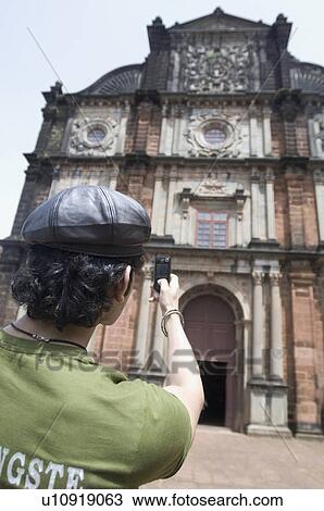 Rear view of a man taking a picture of a building with a mobile phone, Goa, India View Large Photo Image Stock Image - Rear view of a man taking a picture of a building with a mobile phone, Goa, India. Fotosearch