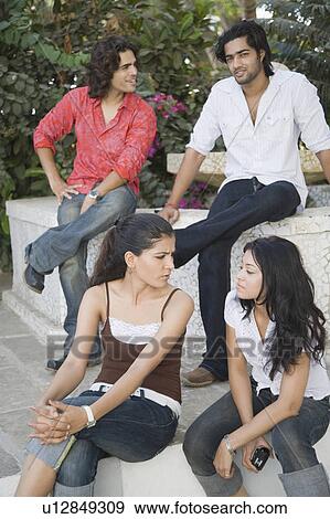 Two young men and two young women sitting together View Large Photo Image Stock Photo - Two young men and two young women sitting together. Fotosearch