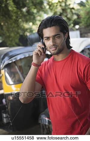 Stock Photo - Young man talking on a mobile phone. Fotosearch