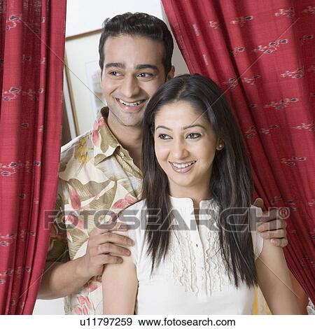 Stock Photo - Close-up of a young couple standing together and smiling. Fotosearch