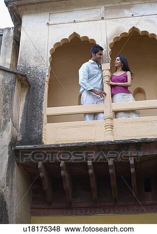 Stock Photo - Low angle view of a young couple leaning against a column of a palace, Neemrana Fort Palace, Neemrana, Alwar, Rajasthan, India. Fotosearch