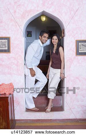 Portrait of a young couple standing under an arch and smiling View Large Photo Image Stock Photo - Portrait of a young couple standing under an arch and smiling. Fotosearch