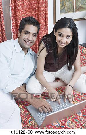 Portrait of a young couple using a laptop and smiling View Large Photo Image Stock Image - Portrait of a young couple using a laptop and smiling. Fotosearch