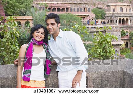 Young couple leaning against a wall and smiling with a palace in the background, Neemrana Fort Palace, Neemrana, Alwar, Rajasthan, India View Large Photo Image Stock Photo - Young couple leaning against a wall and smiling with a palace in the background, Neemrana Fort Palace, Neemrana, Alwar, Rajasthan, India. Fotosearch